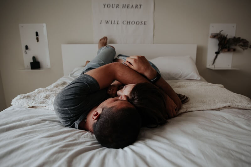 Ett par som ligger i en säng där mannen fått hjälp online för sina potensbesvär.